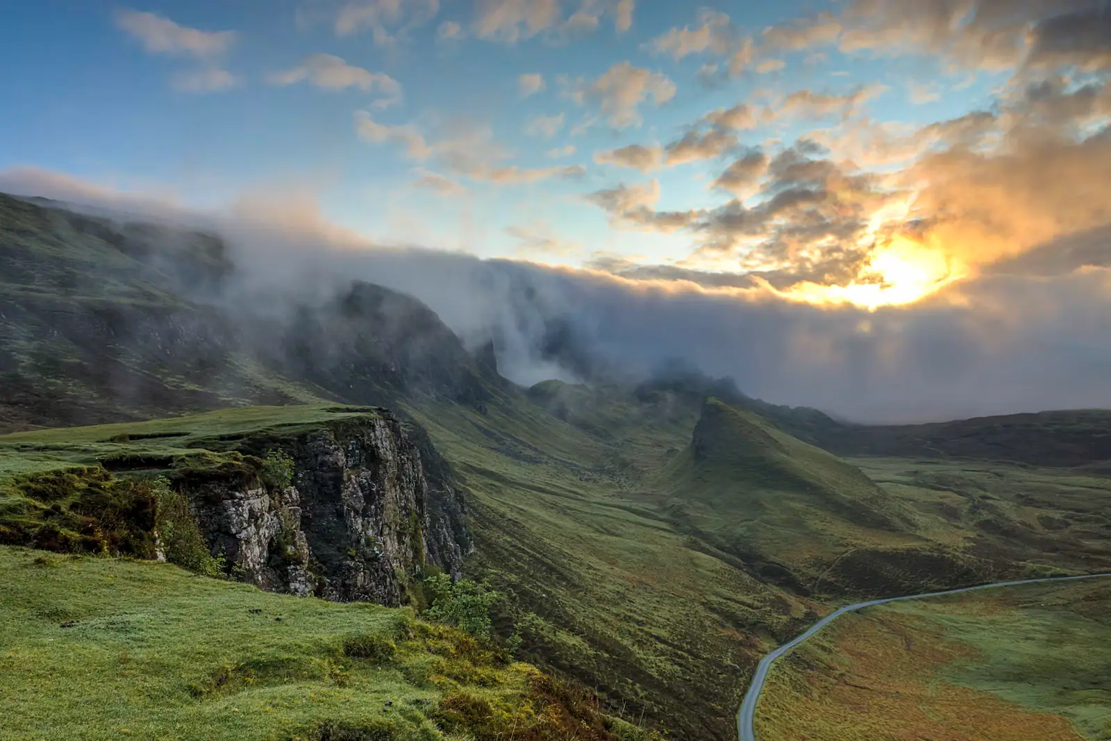 A bare volcanic ridgeline standing above a sea of cloud at first light