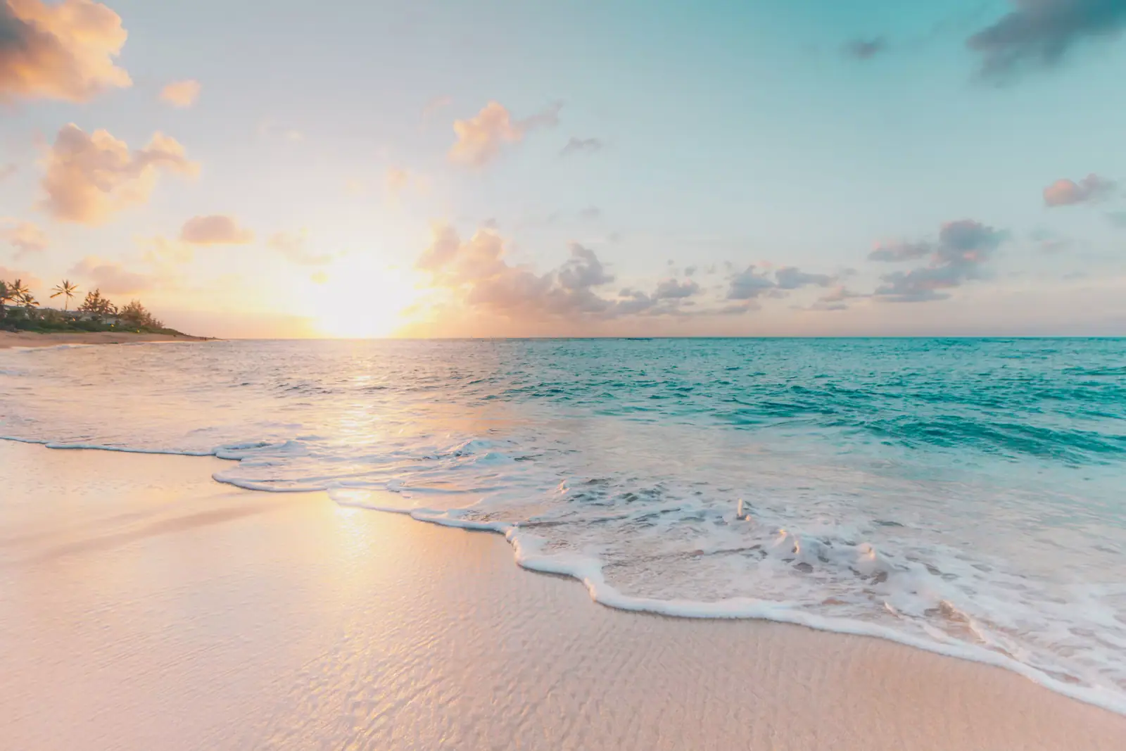 Clear turquoise shallows running onto pale sand